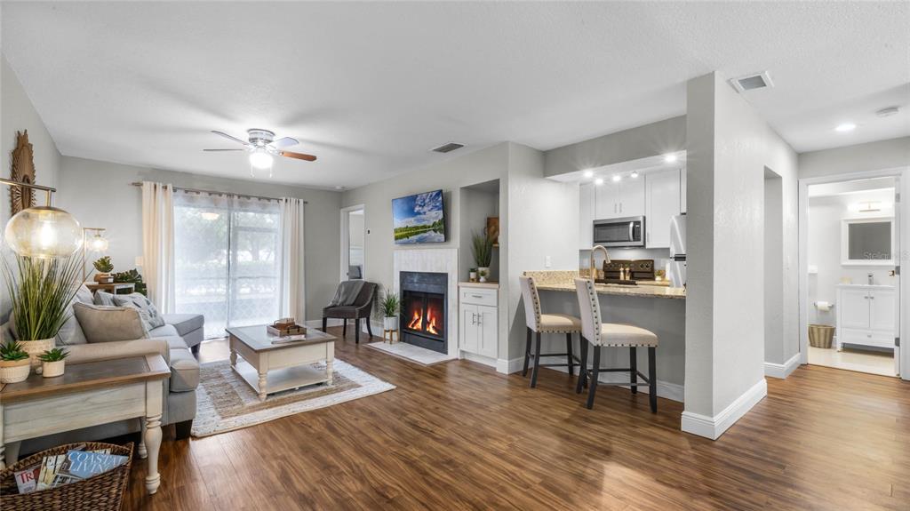 524 Sun Valley Villiage, Unit 105 Altamonte Springs, FL 32714 - Photo 1 of 27 a living room with furniture wooden floor and a kitchen view