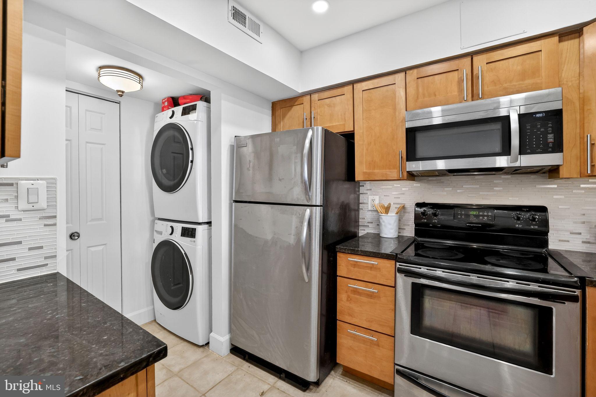 3805 Porter Street Northwest, Unit 201 Washington, DC 20016 - Photo 13 of 19 a kitchen with stainless steel appliances a stove a microwave and a sink