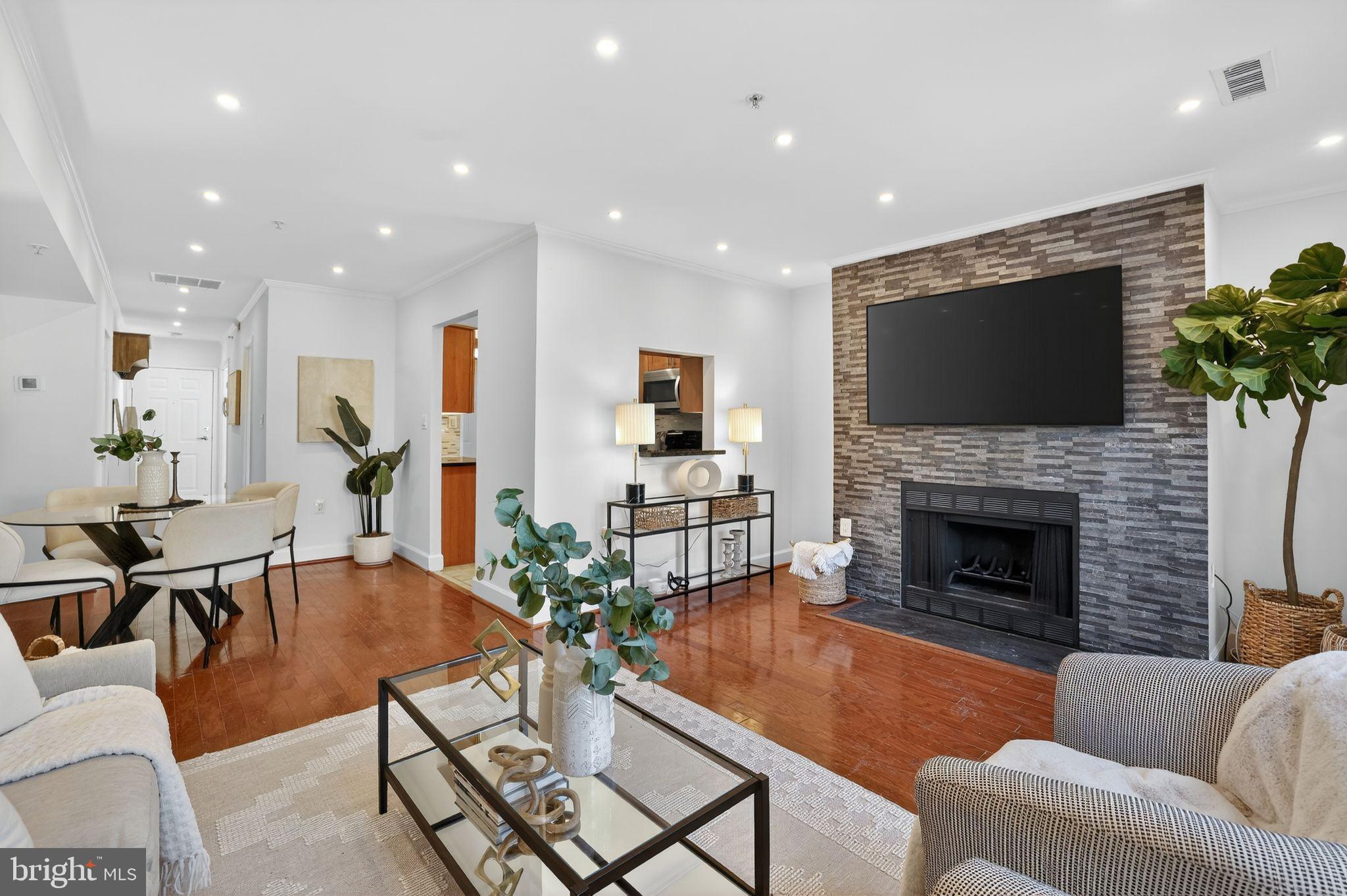 3805 Porter Street Northwest, Unit 201 Washington, DC 20016 - Photo 9 of 19 a living room with furniture a flat screen tv and a fireplace