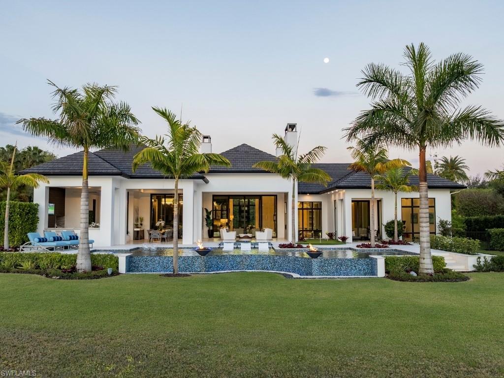 6199 Highcroft Drive Naples, FL 34119 - Photo 2 of 45 Back of property at dusk featuring an infinity edge pool