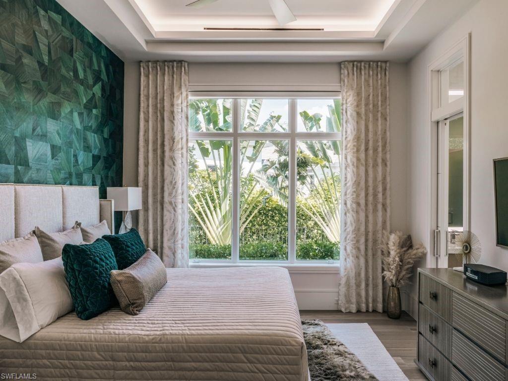 6199 Highcroft Drive Naples, FL 34119 - Photo 23 of 45 Second Primary Bedroom with an accent wallpapered wall, wood finished floors, and a tray ceiling