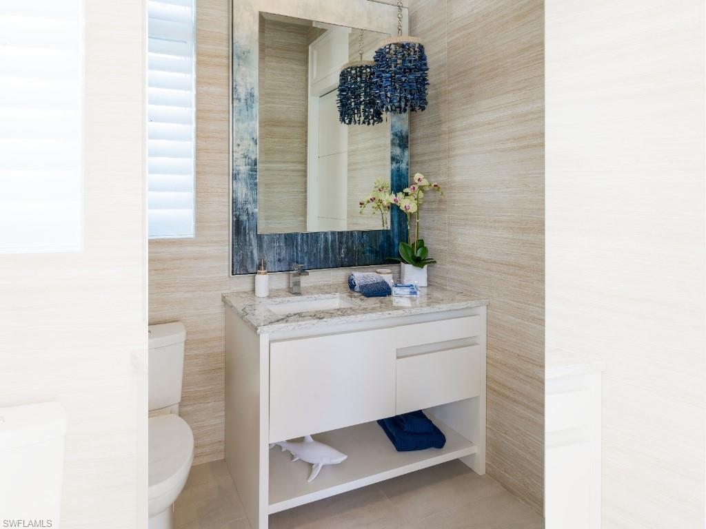 6199 Highcroft Drive Naples, FL 34119 - Photo 30 of 45 Pool bath full tiled walls, custom mirror and shell chandelier