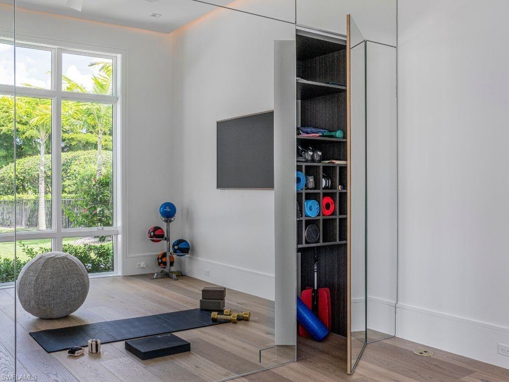 6199 Highcroft Drive Naples, FL 34119 - Photo 32 of 45 Exercise room featuring floor to ceiling mirrored wall