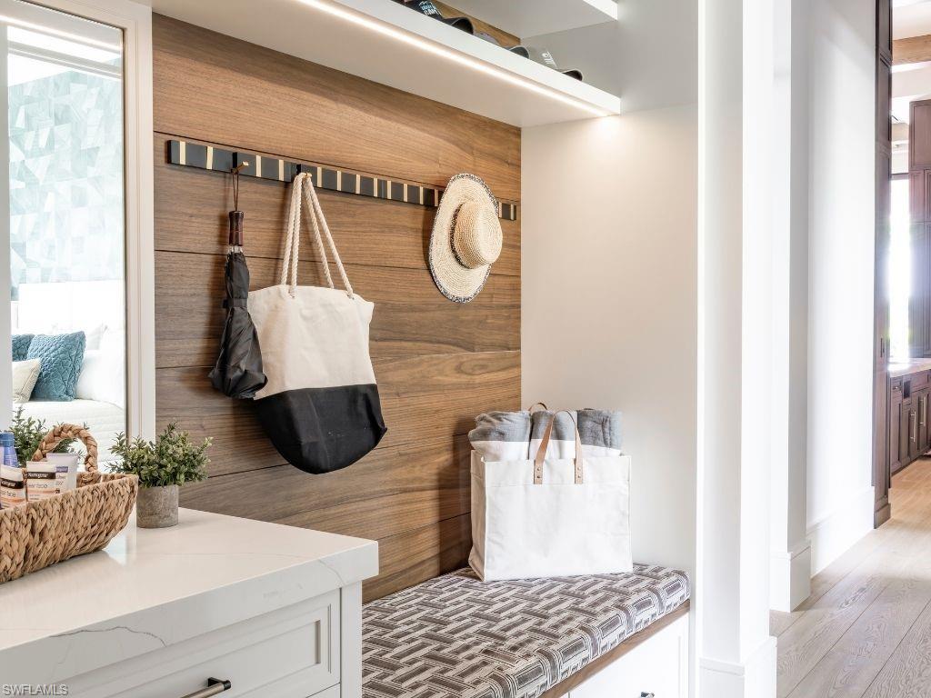 6199 Highcroft Drive Naples, FL 34119 - Photo 33 of 45 Hallway shoe drop with wooden slatting and mirror