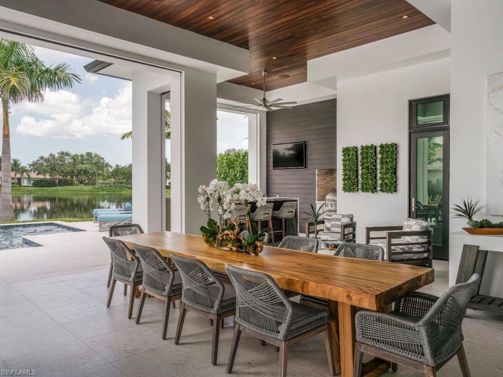 6199 Highcroft Drive Naples, FL 34119 - Photo 41 of 45 Outdoor dining area with a grand live-edge table easily seating 10 guests