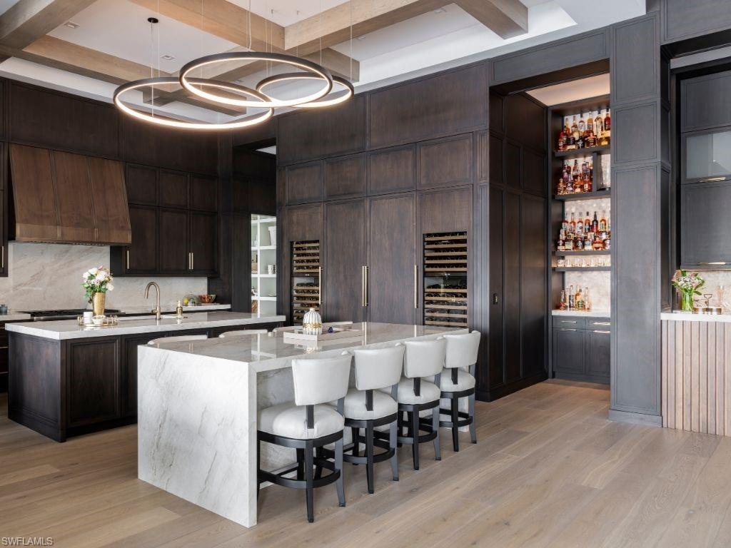 6199 Highcroft Drive Naples, FL 34119 - Photo 8 of 45 Kitchen with double island, 2 wine chillers, a backlight Cristalo bar, hidden wine cellar holding 900 bottles
