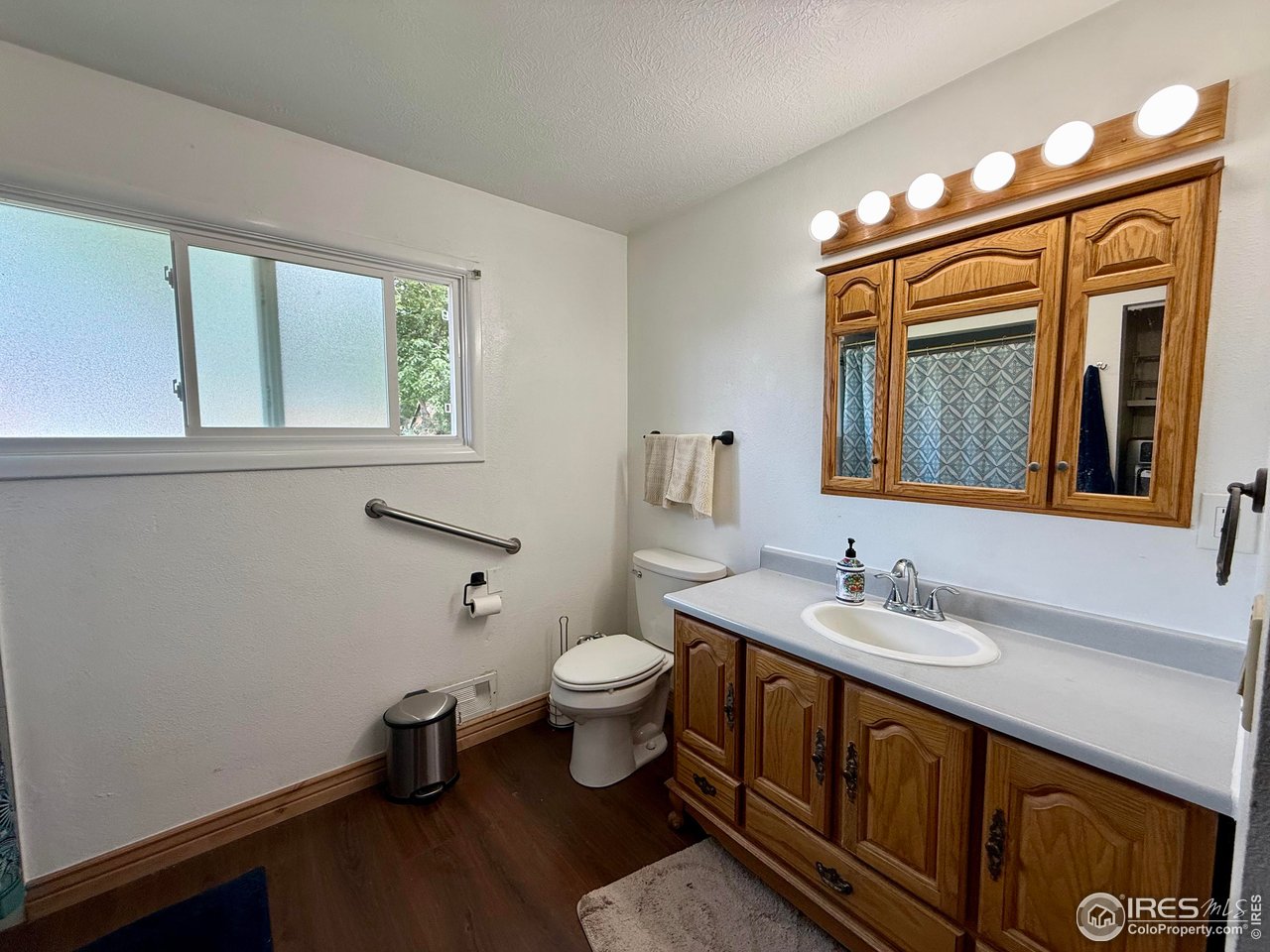406 South Morlan Avenue Holyoke, CO 80734 - Photo 12 of 38 a bathroom with a toilet a sink and a large mirror