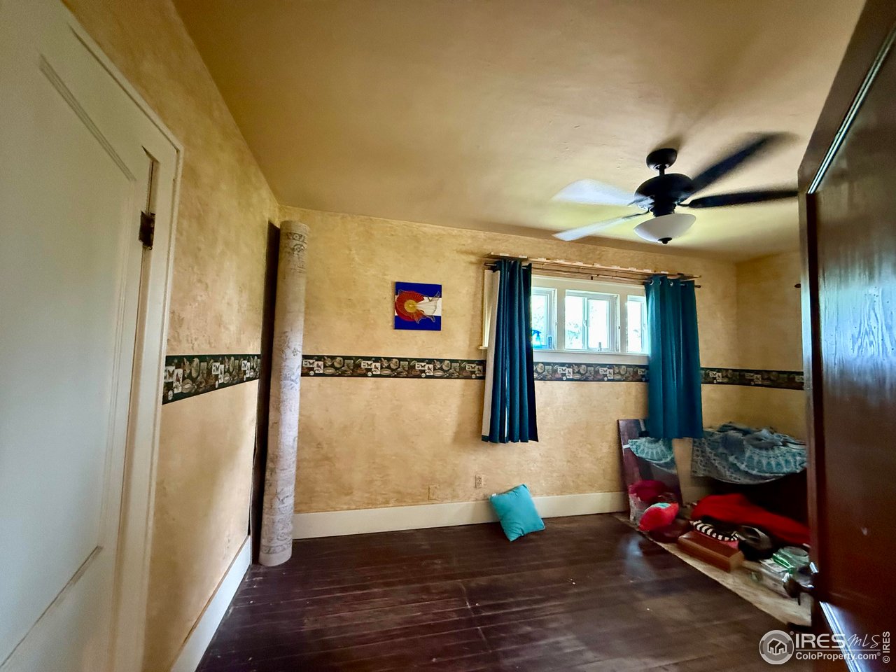 406 South Morlan Avenue Holyoke, CO 80734 - Photo 16 of 38 a very nice looking room with a large window and wooden floor