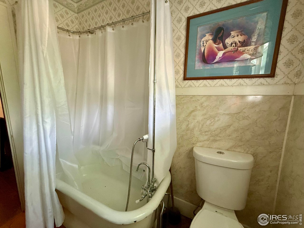 406 South Morlan Avenue Holyoke, CO 80734 - Photo 19 of 38 a bathroom with a toilet and a shower curtain