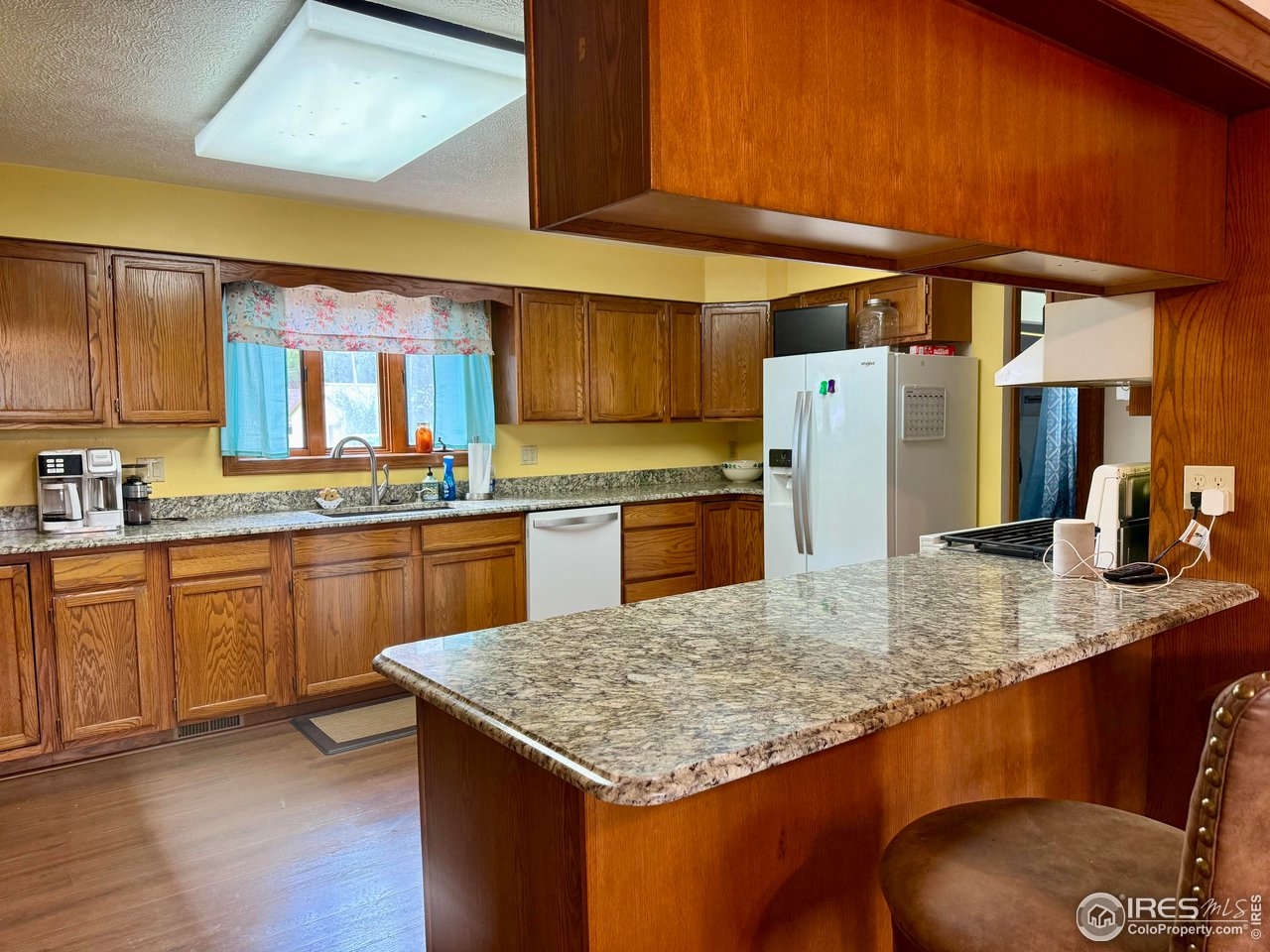 406 South Morlan Avenue Holyoke, CO 80734 - Photo 7 of 38 a kitchen with stainless steel appliances granite countertop a sink dishwasher stove refrigerator and cabinets