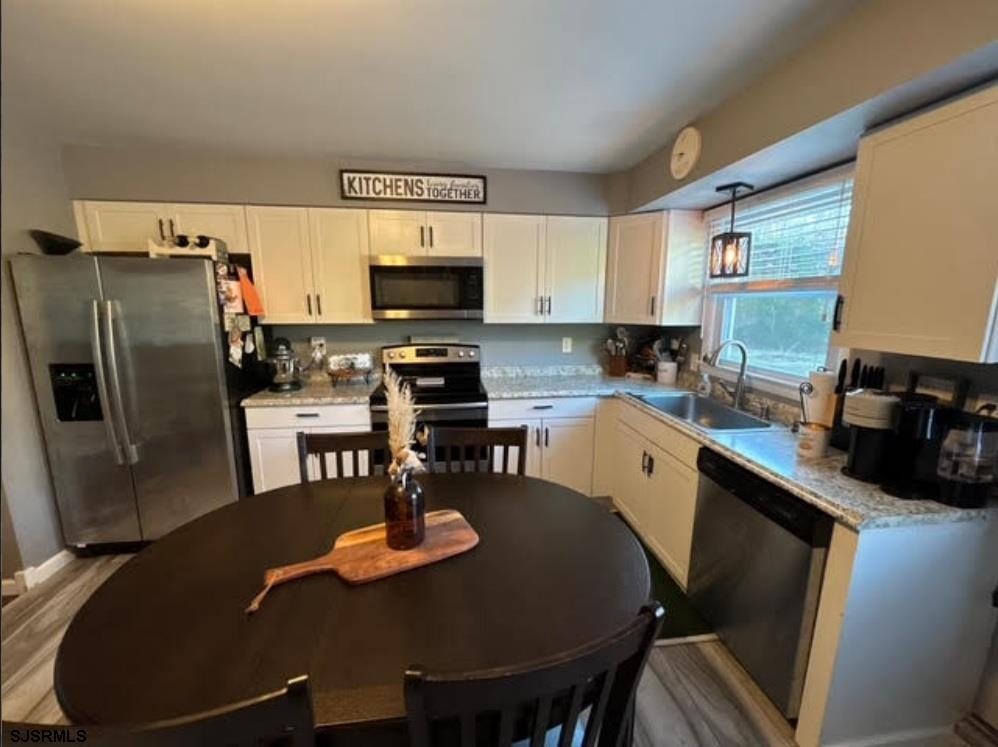 6936 Casale Boulevard Mays Landing, NJ 08330 - Photo 4 of 9 a kitchen with stainless steel appliances granite countertop a sink a stove a kitchen island and chairs