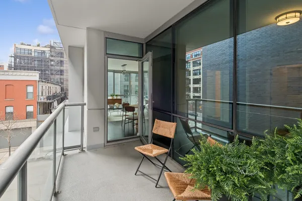 a balcony with chairs and a potted plant