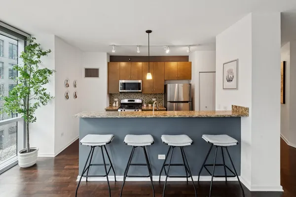 a kitchen with a table chairs refrigerator and microwave