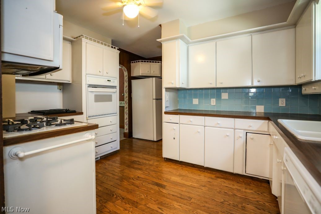 728 East Riddle Avenue Ravenna, OH 44266 - Photo 14 of 40 Kitchen with white appliances, white cabinets, backsplash, dark hardwood / wood-style flooring, and ceiling fan