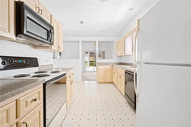 a kitchen with granite countertop white cabinets and white appliances