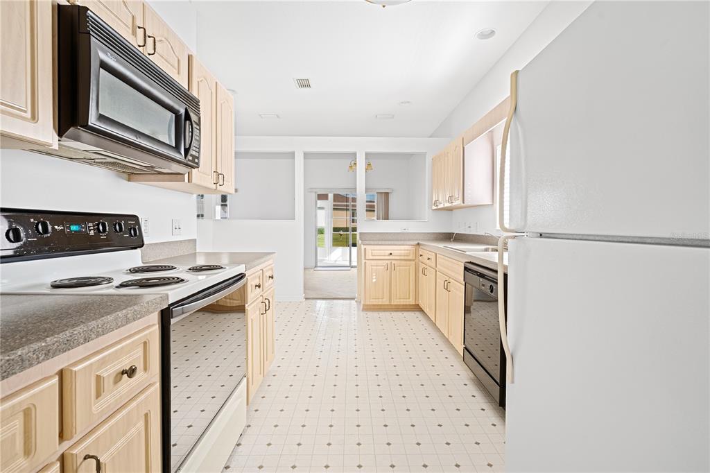 2459 Northwest 55th Avenue Road Ocala, FL 34482 - Photo 12 of 38 a kitchen with a stove top oven sink and cabinets