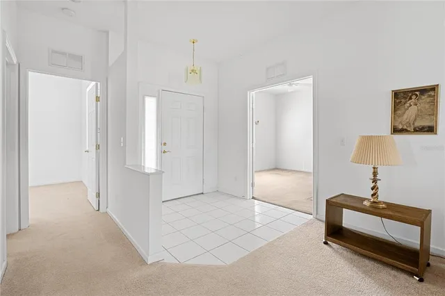 a spacious bedroom with a bed and a lamp