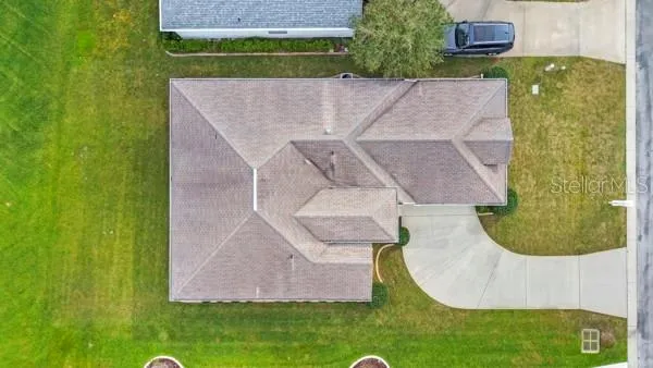 a front view of a house with a garden and lake view