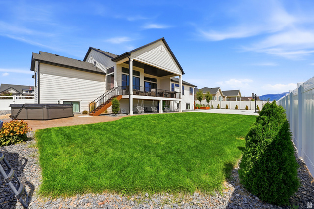 4331 West 475 South West Point, UT 84015 - Photo 42 of 46 Expansive backyard featuring a manicured lawn, a concrete patio, a privacy fence, and a covered upper deck with a staircase
