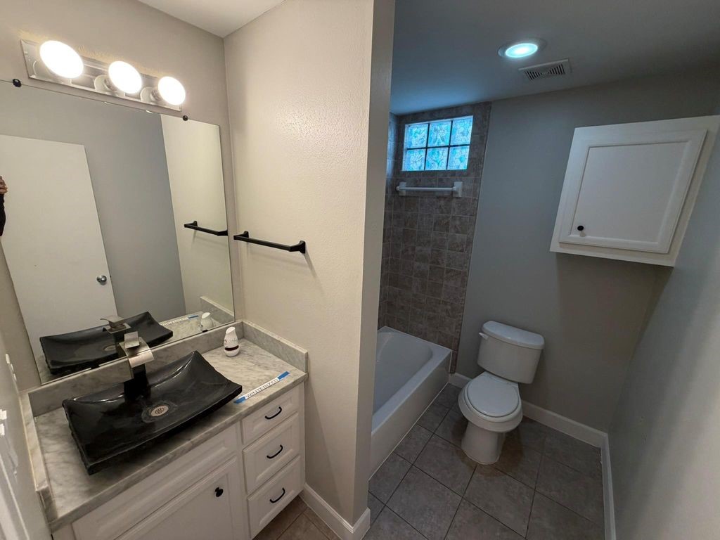 2710 Hullsmith Drive, Unit 701 Houston, TX 77063 - Photo 6 of 19 a bathroom with a sink a toilet and shower