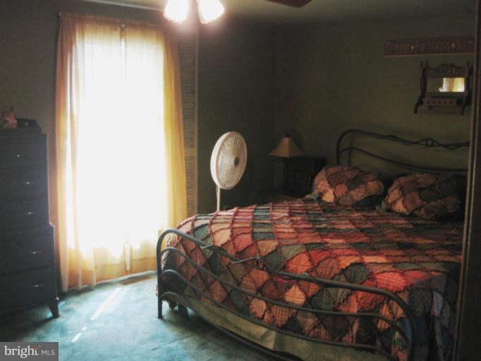 28731 Kemptown Road Mount Airy, MD 21771 - Photo 17 of 30 a bed sitting in a bedroom next to a window