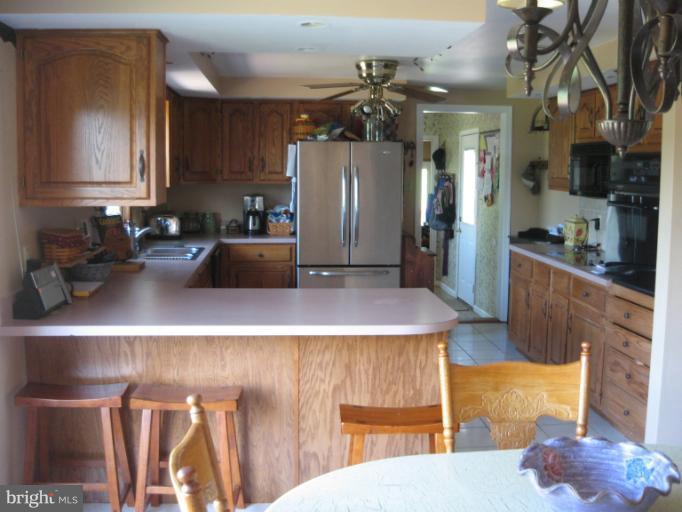 28731 Kemptown Road Mount Airy, MD 21771 - Photo 19 of 30 a kitchen with stainless steel appliances kitchen island granite countertop a refrigerator a stove and a sink with dishwasher