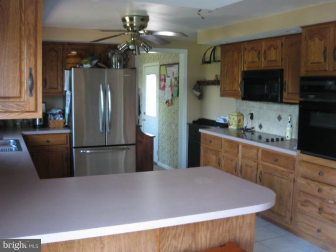 28731 Kemptown Road Mount Airy, MD 21771 - Photo 30 of 30 a kitchen with stainless steel appliances a refrigerator a sink a stove a microwave a counter top and cabinets