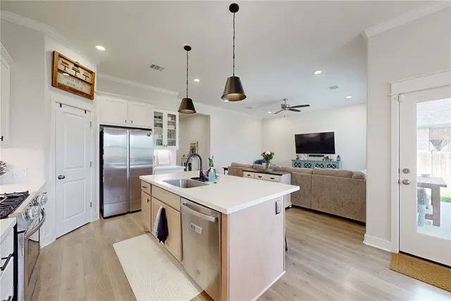 a kitchen that has a sink a microwave a stove and a refrigerator