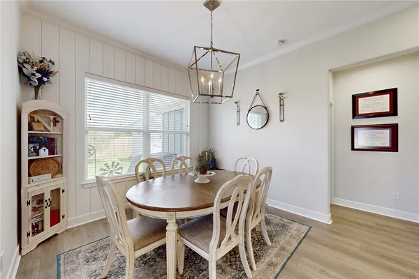 a dining room with wooden floor and a chandelier
