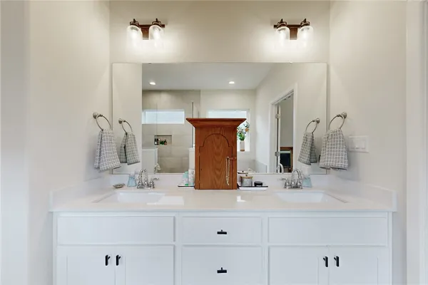 a bathroom with double vanity sink and a mirror