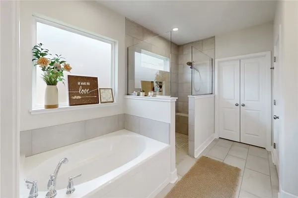 a bathroom with a tub sink and mirror