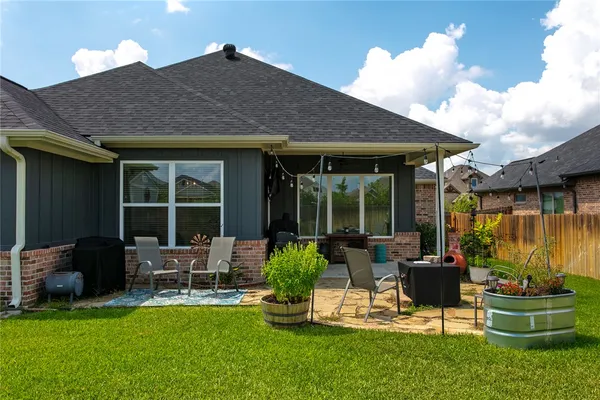 a view of a house with backyard sitting area and garden