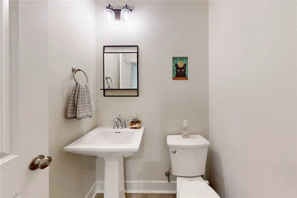 a bathroom with a toilet a sink and mirror