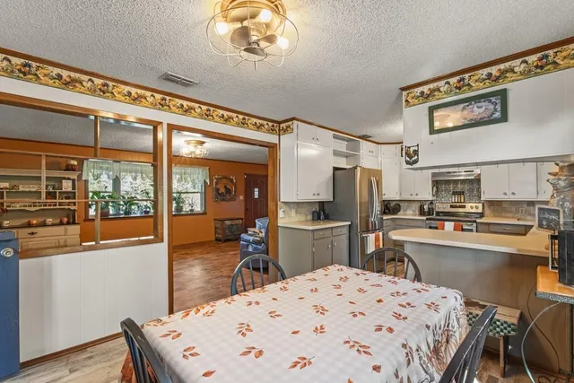 a kitchen with a table chairs stove and refrigerator