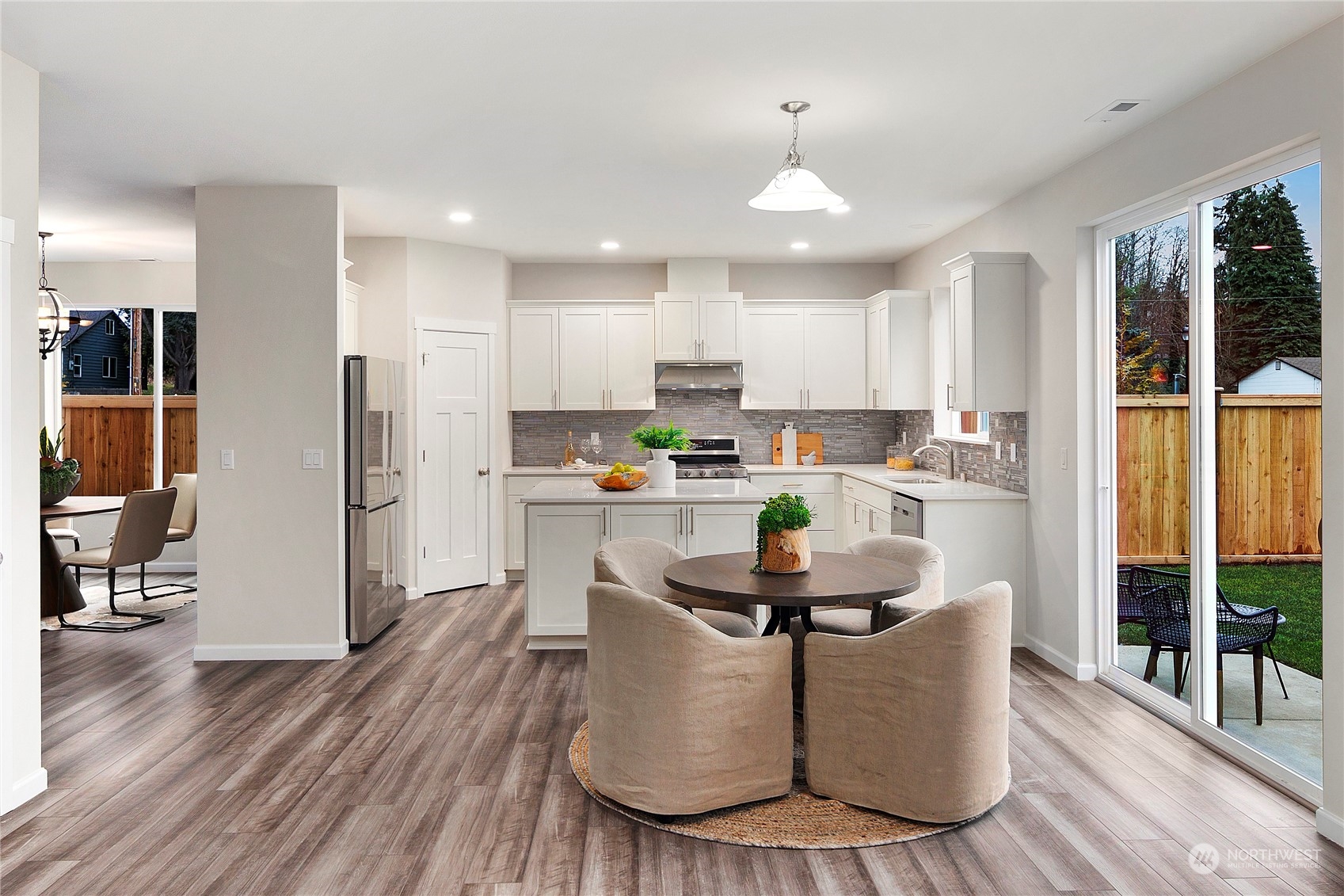 10981 Southeast 165th Street Renton, WA 98055 - Photo 8 of 38 a kitchen with stainless steel appliances granite countertop a refrigerator a sink dishwasher a stove and a dining table with wooden floor