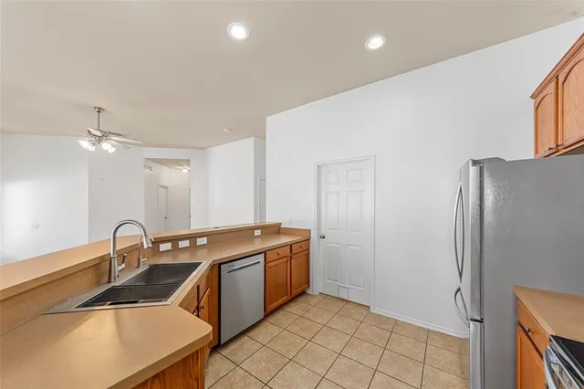 a kitchen that has a sink a stove and a refrigerator