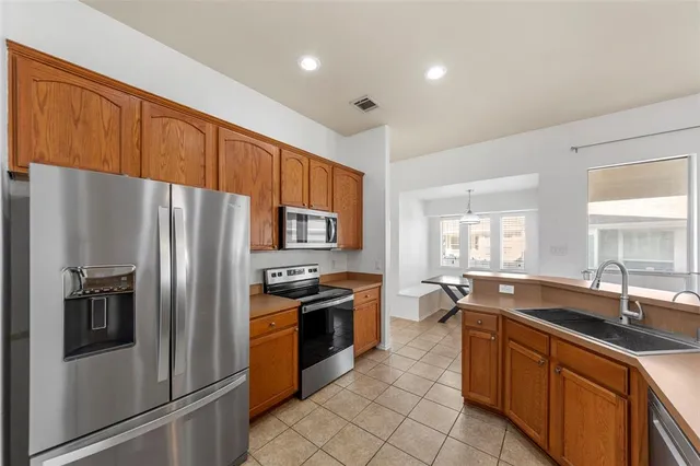 a kitchen with stainless steel appliances granite countertop a stove refrigerator sink and dishwasher
