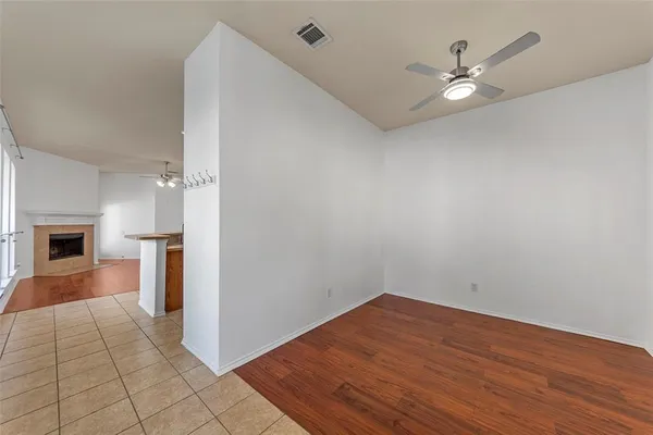 an empty room with wooden floor fireplace and windows