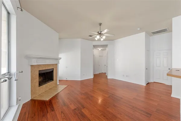 a view of empty room with wooden floor and fireplace