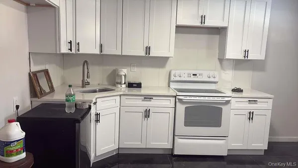 a kitchen with white cabinets and appliances