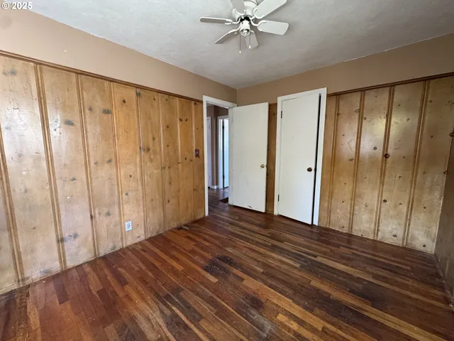 a view of a room with wooden floor and fan