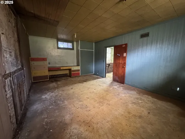 a storage room with water heater and wooden cabinets