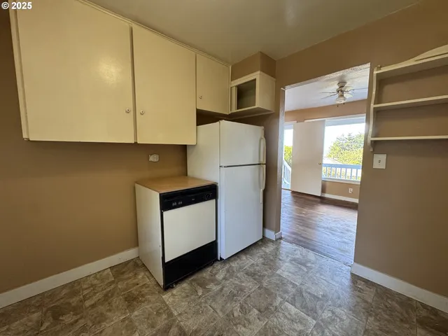 a kitchen with a refrigerator and a stove top oven