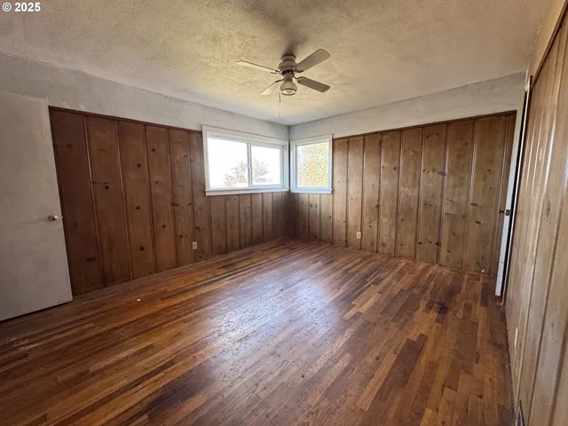 a view of a livingroom with wooden floor and a ceiling fan