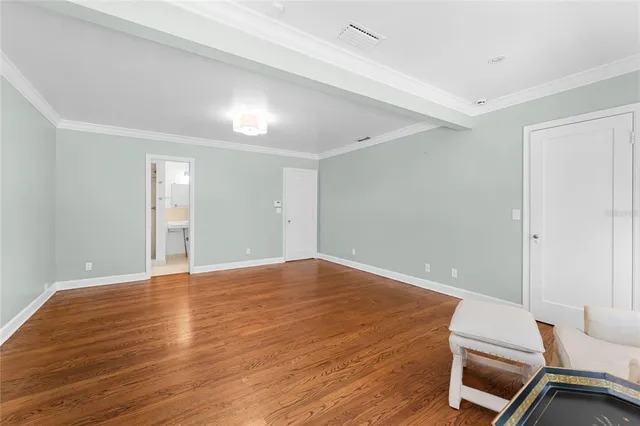 a view of an empty room with wooden floor