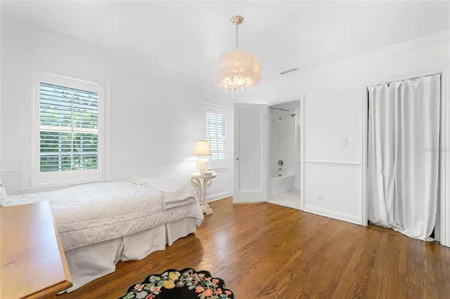 a spacious bedroom with a bed and a chandelier
