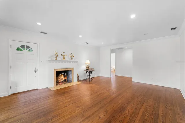 a view of empty room with wooden floor and fireplace