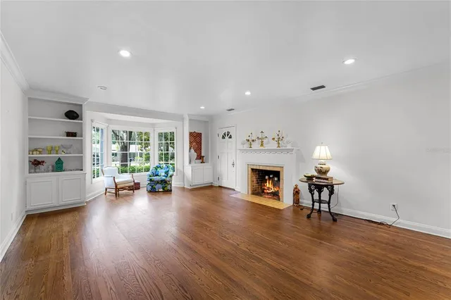 a view of empty room with wooden floor and fireplace