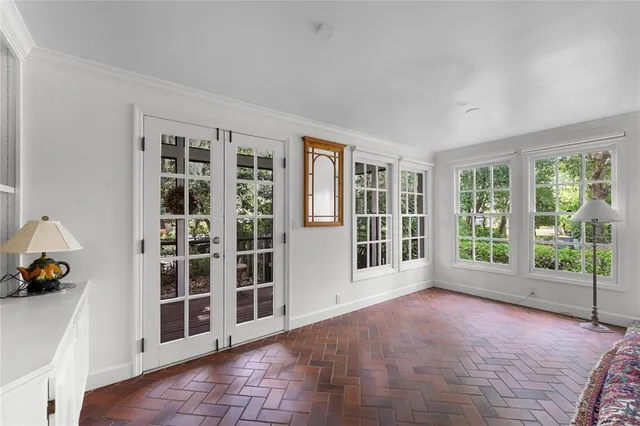 a view of an empty room with windows and lounge chair