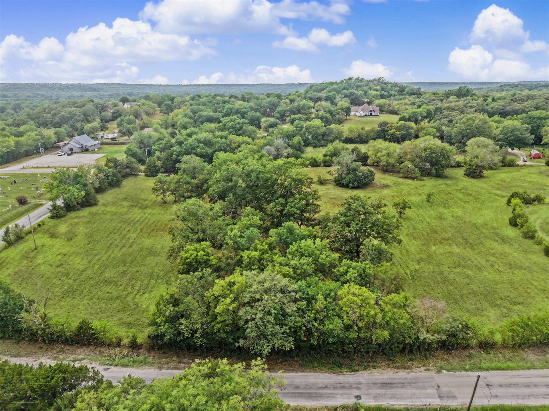 394290 West 4100th Road Skiatook, OK 74070 - Photo 38 of 41 Expansive rural landscape featuring lush green fields and dense mature trees